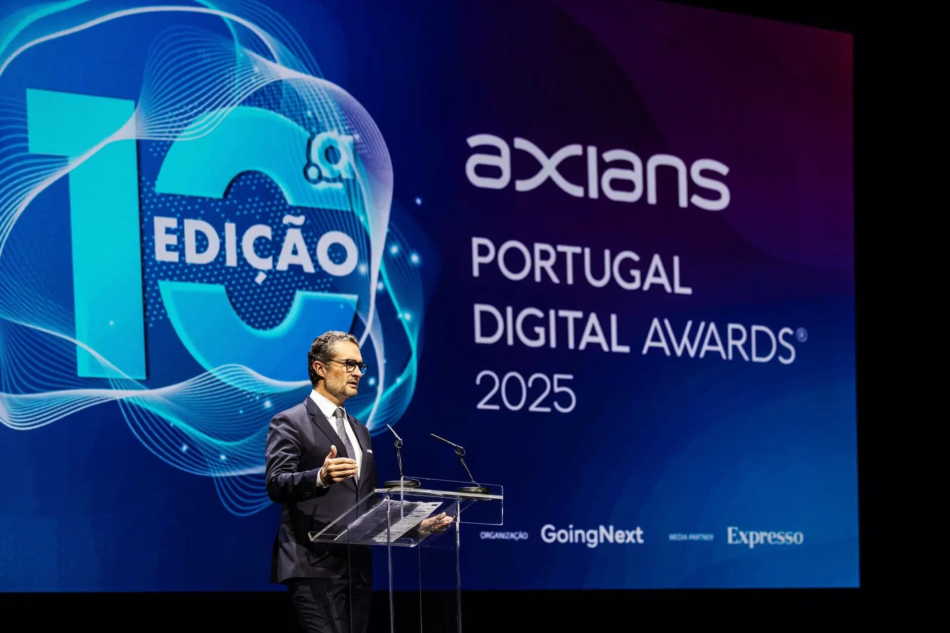 The Secretary of State for Digitalisation at the transparent lectern, in front of the 10th Axians Portugal Digital Awards screen