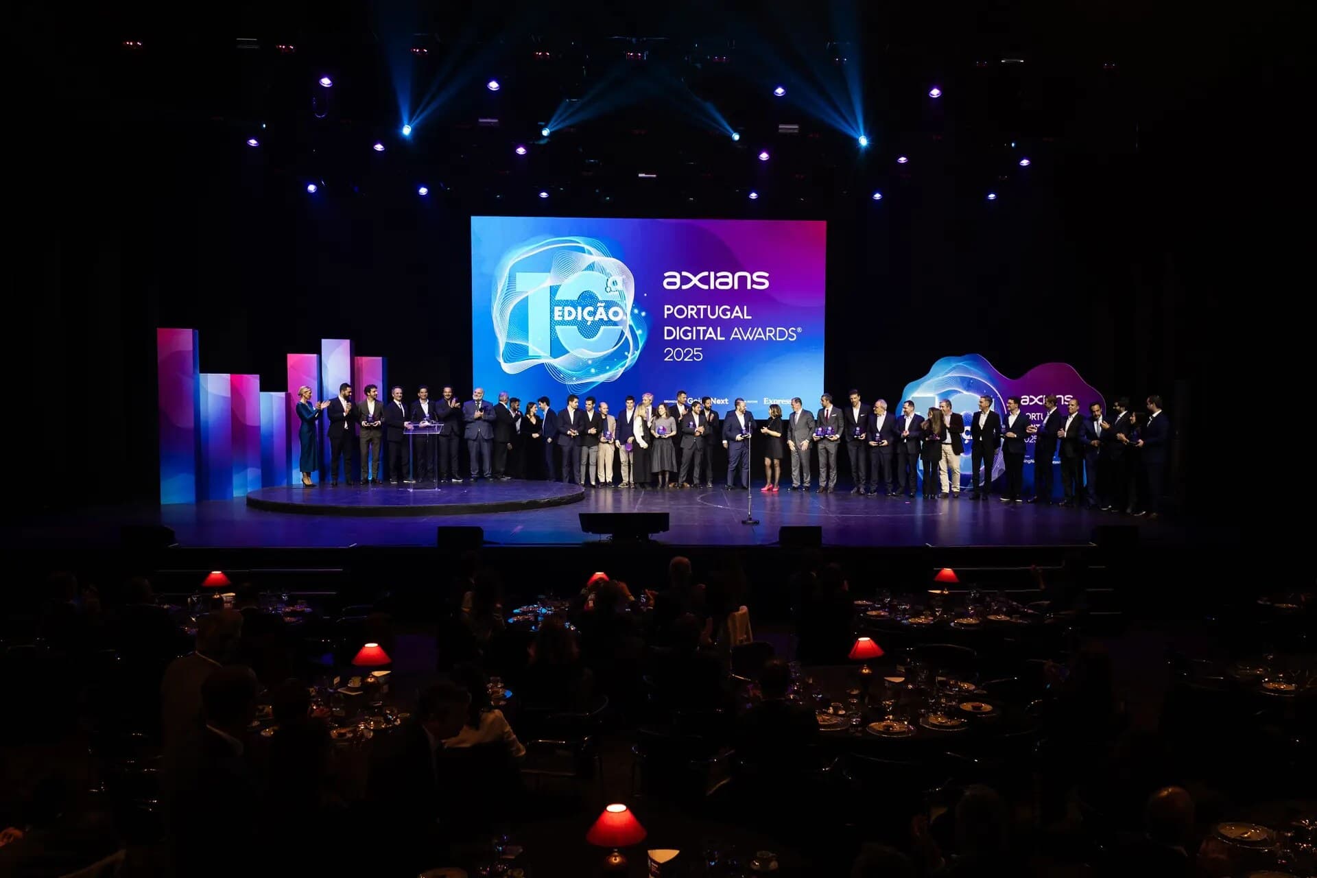 O palco do Casino do Estoril com todos os premiados em fila, à frente do ecrã da 10.ª edição, e as mesas do jantar às escuras em primeiro plano